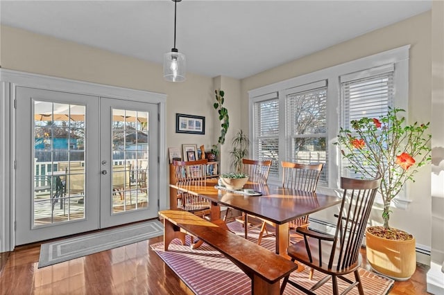 dining room featuring a baseboard heating unit, hardwood / wood-style floors, and french doors