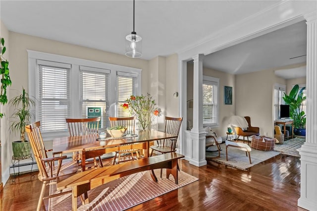 dining area with dark hardwood / wood-style flooring and decorative columns