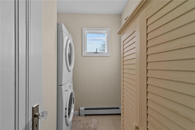 laundry room with light hardwood / wood-style floors, stacked washer / dryer, and baseboard heating