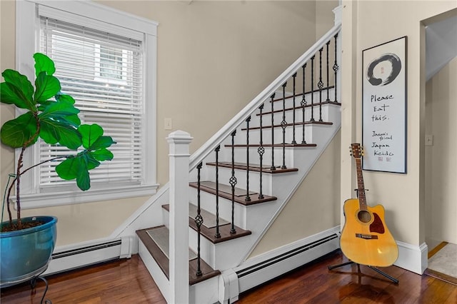 stairs with wood-type flooring and baseboard heating