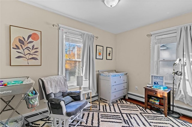 living area with wood-type flooring and baseboard heating