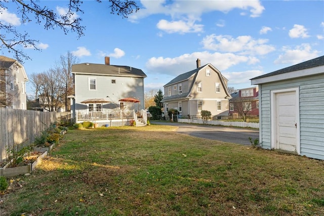 back of property featuring a deck and a lawn