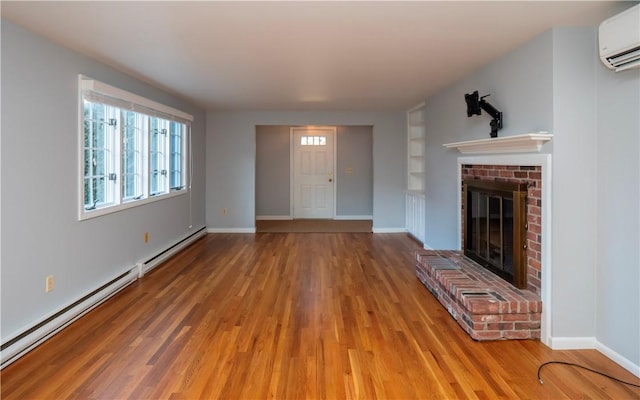 unfurnished living room with a fireplace, hardwood / wood-style floors, a wall unit AC, and a baseboard heating unit