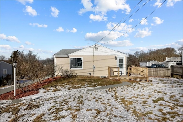 snow covered house with a wooden deck