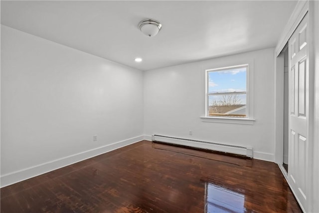 unfurnished bedroom with hardwood / wood-style flooring and a baseboard radiator