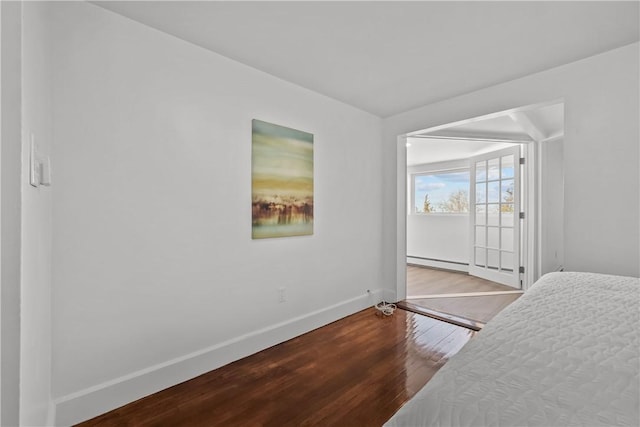 bedroom with hardwood / wood-style flooring and a baseboard radiator