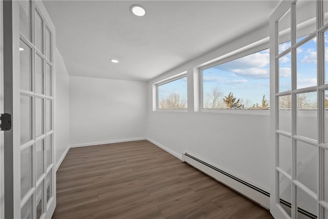 unfurnished room featuring a baseboard radiator and dark hardwood / wood-style flooring