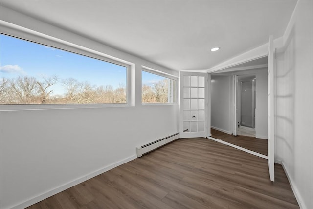 unfurnished bedroom with hardwood / wood-style floors and a baseboard radiator