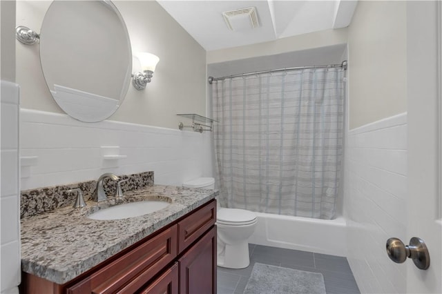 full bathroom with tile walls, shower / tub combo, vanity, tile patterned floors, and toilet