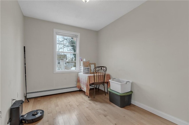 interior space featuring a baseboard heating unit and light hardwood / wood-style floors