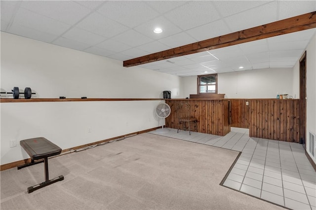 tiled empty room featuring indoor bar and a drop ceiling