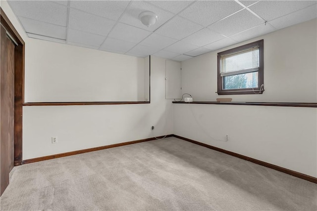 carpeted spare room with a paneled ceiling