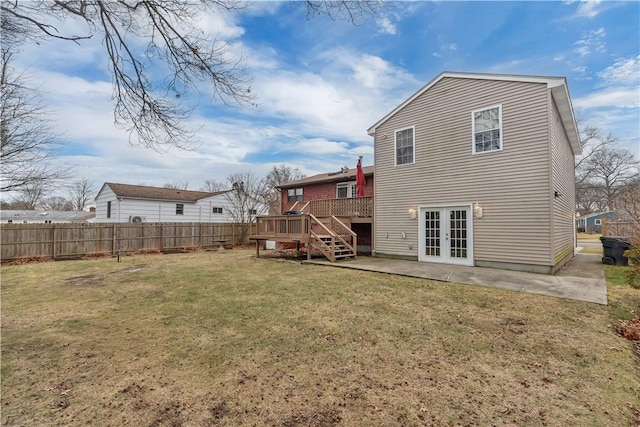 rear view of house with a patio, a lawn, french doors, and a deck