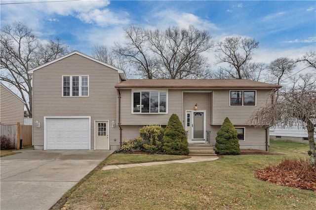 raised ranch featuring a garage and a front lawn