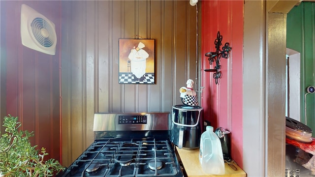 interior space featuring gas stove and wood walls