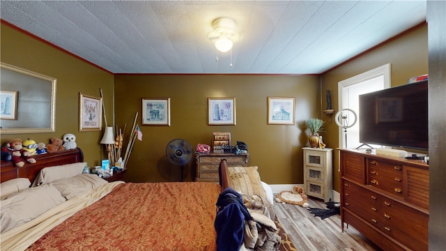 bedroom with light hardwood / wood-style flooring and ornamental molding