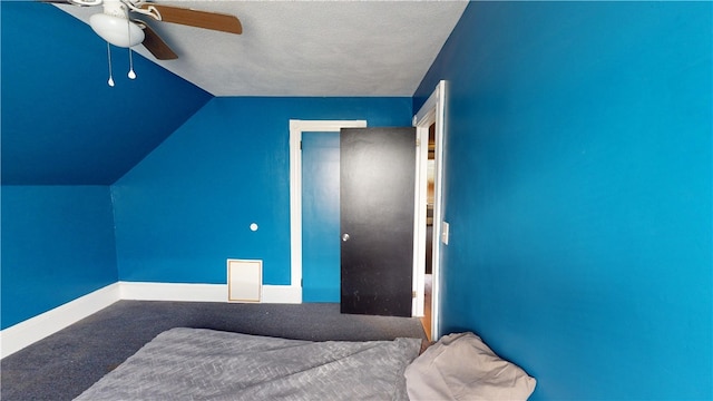 unfurnished bedroom with lofted ceiling, carpet floors, a textured ceiling, and ceiling fan