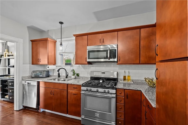 kitchen with sink, tasteful backsplash, hanging light fixtures, dark hardwood / wood-style flooring, and stainless steel appliances