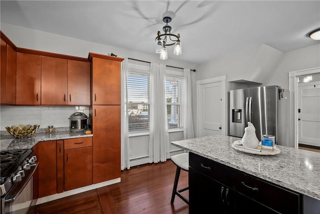 kitchen featuring dark hardwood / wood-style floors, pendant lighting, stainless steel appliances, decorative backsplash, and a baseboard heating unit