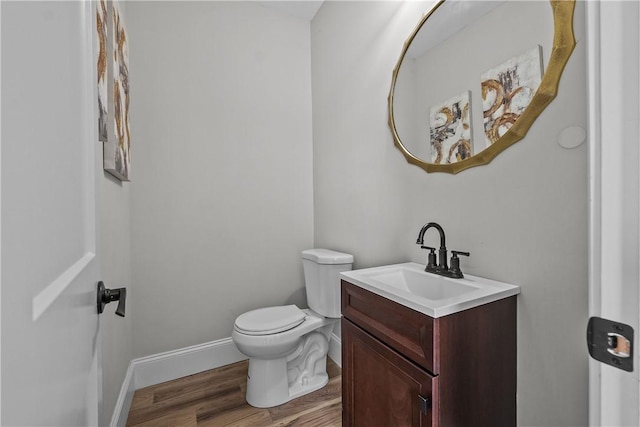 bathroom with vanity, wood-type flooring, and toilet