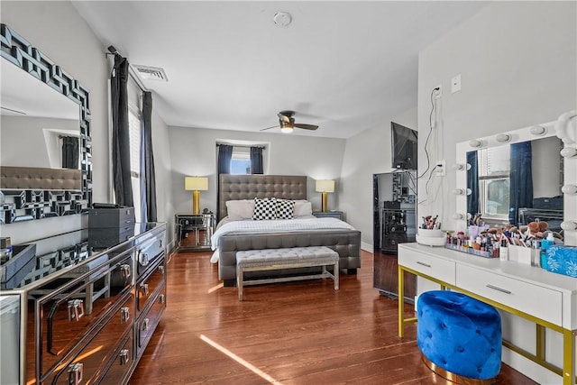 bedroom featuring dark hardwood / wood-style flooring, multiple windows, and ceiling fan