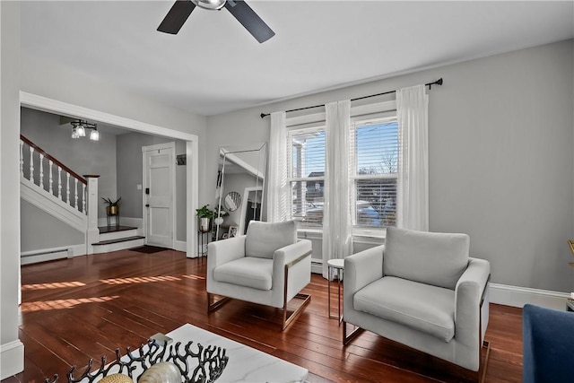 living area with ceiling fan, dark hardwood / wood-style floors, and baseboard heating