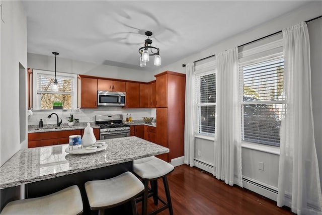 kitchen with sink, tasteful backsplash, decorative light fixtures, appliances with stainless steel finishes, and plenty of natural light