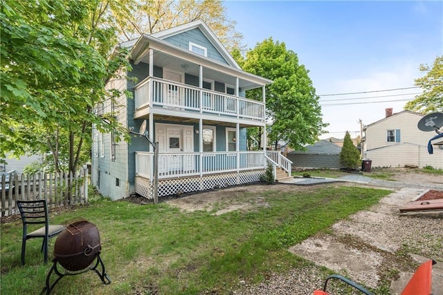 view of front of property with a balcony, a porch, and a front lawn