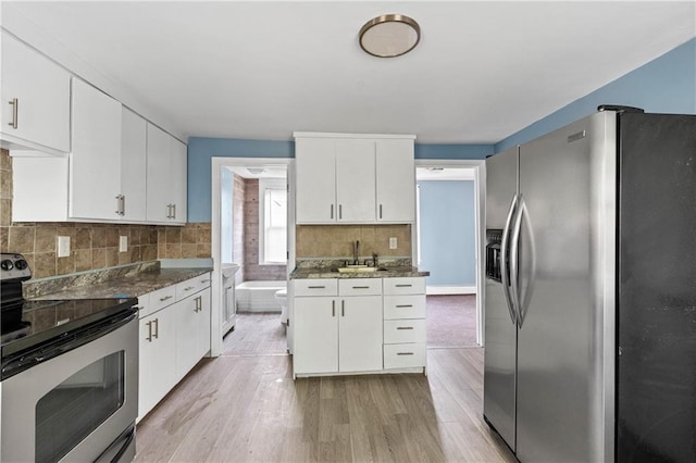 kitchen with appliances with stainless steel finishes, light hardwood / wood-style floors, and white cabinets