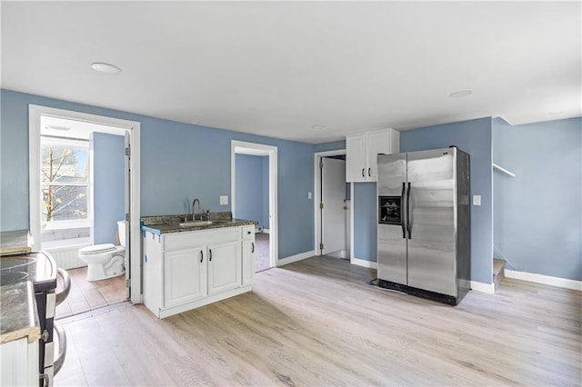 kitchen featuring white cabinetry, sink, stainless steel appliances, and light wood-type flooring