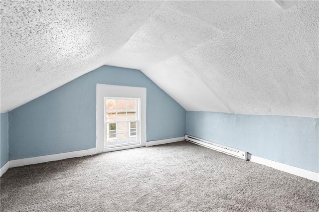 additional living space featuring a baseboard radiator, vaulted ceiling, carpet, and a textured ceiling