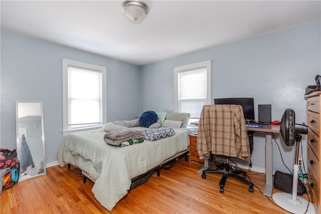 bedroom with multiple windows and light wood-type flooring