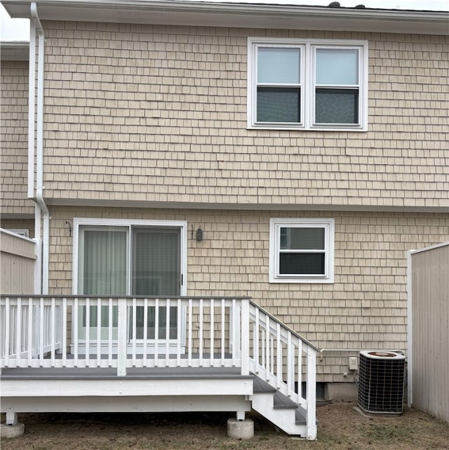 rear view of property with cooling unit and a deck