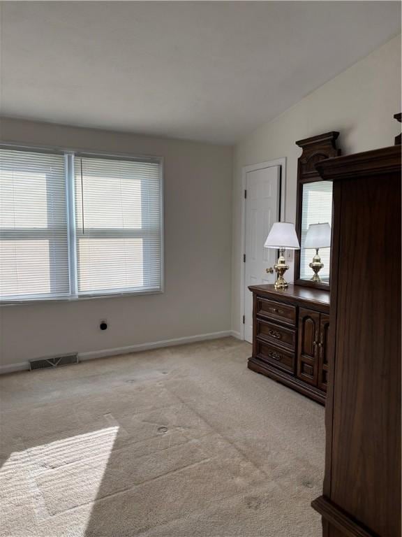 bedroom with vaulted ceiling and light carpet