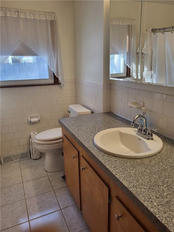 bathroom featuring vanity, tile walls, tile patterned floors, and toilet