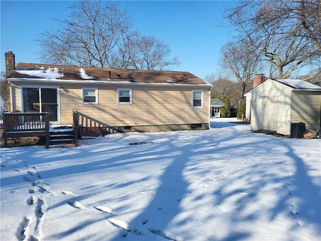 snow covered property featuring a shed and a wooden deck