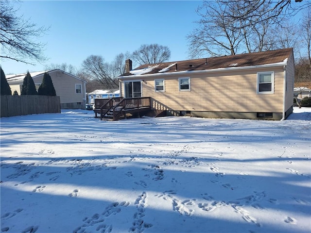 snow covered back of property featuring a wooden deck