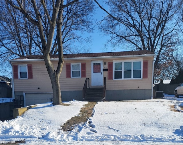 view of front of house with a garage and cooling unit