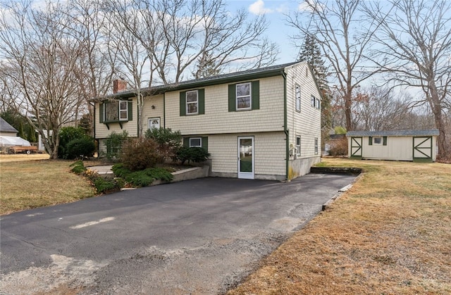 split foyer home featuring a storage shed and a front yard