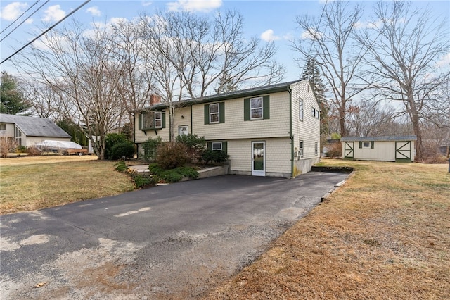 bi-level home with a front lawn and a storage unit