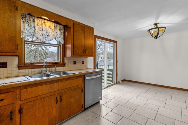 kitchen featuring plenty of natural light, tile countertops, dishwasher, and sink