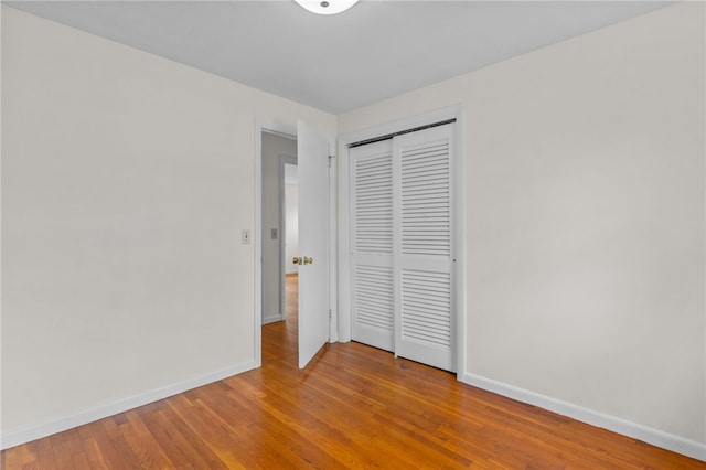 unfurnished bedroom with hardwood / wood-style flooring and a closet