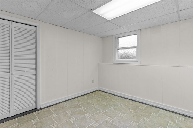 basement with a paneled ceiling