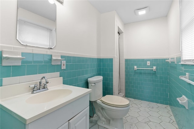 bathroom featuring vanity, tile walls, tile patterned floors, and toilet