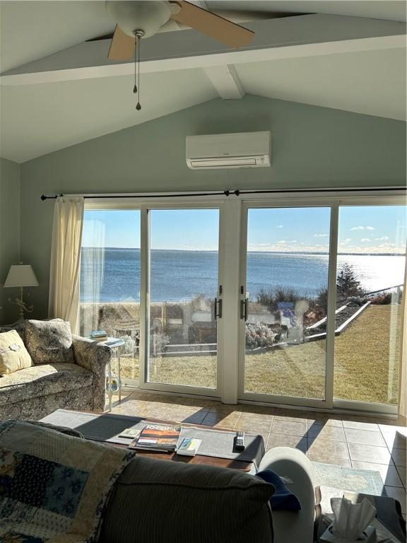 interior space featuring a water view, an AC wall unit, vaulted ceiling with beams, and ceiling fan