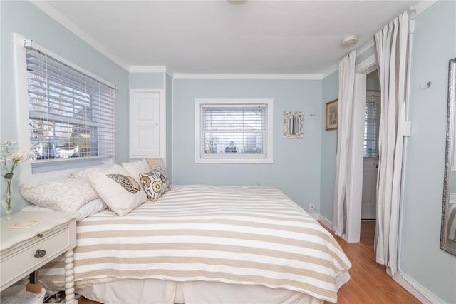 bedroom with ornamental molding and light hardwood / wood-style floors