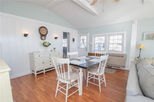 dining area with vaulted ceiling with beams, ceiling fan, radiator heating unit, and light wood-type flooring