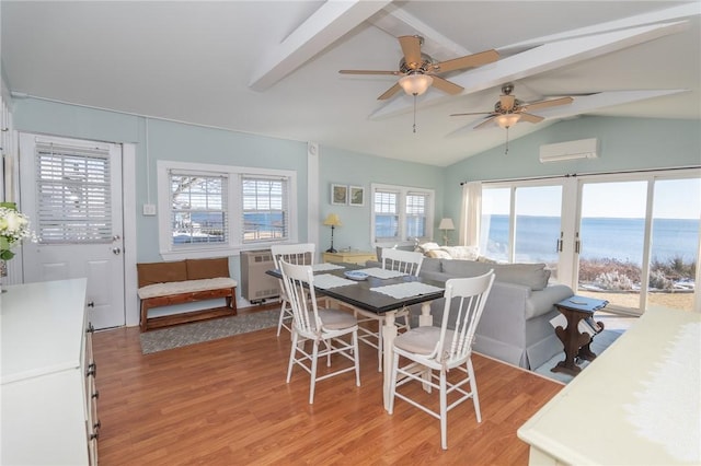 dining space featuring radiator heating unit, a water view, lofted ceiling with beams, an AC wall unit, and light wood-type flooring