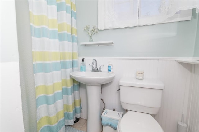 bathroom featuring tile patterned flooring, sink, toilet, and walk in shower