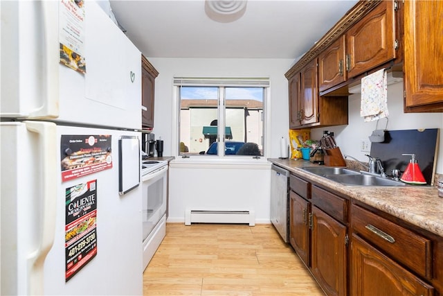 kitchen with a baseboard heating unit, white appliances, sink, and light wood-type flooring